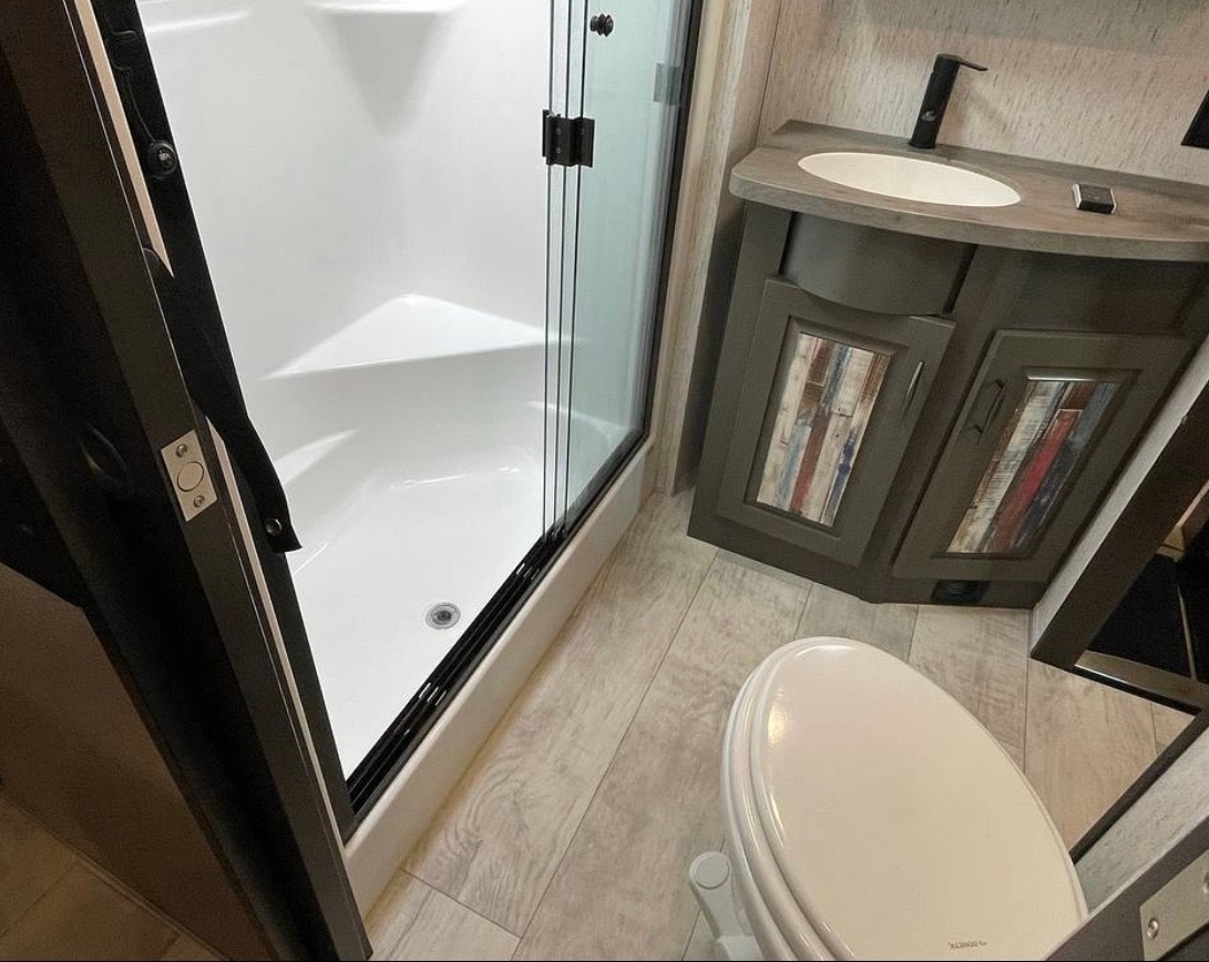 Modern bathroom with glass shower, toilet, and vanity with contemporary finishes