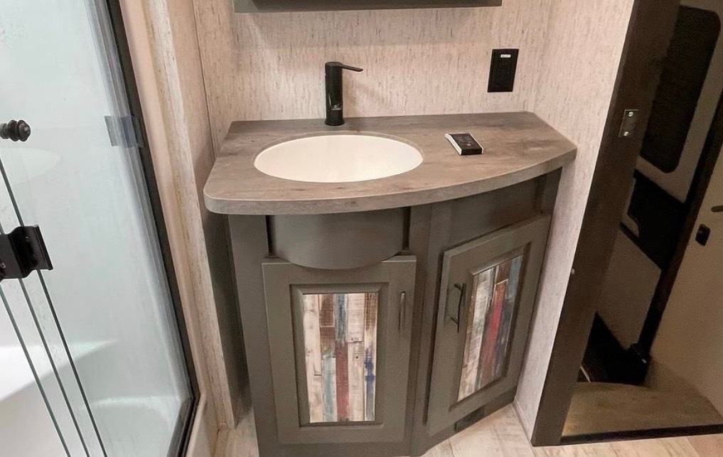 Bathroom vanity with curved countertop and storage cabinet