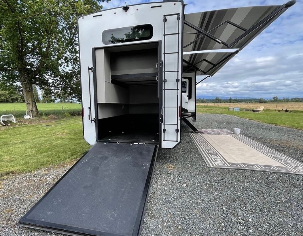 Garage storage compartment under bedroom with shelving and ramp access