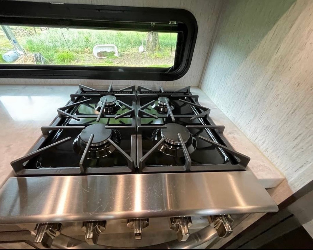 Professional 4-burner gas cooktop with cast iron grates and stainless steel surface