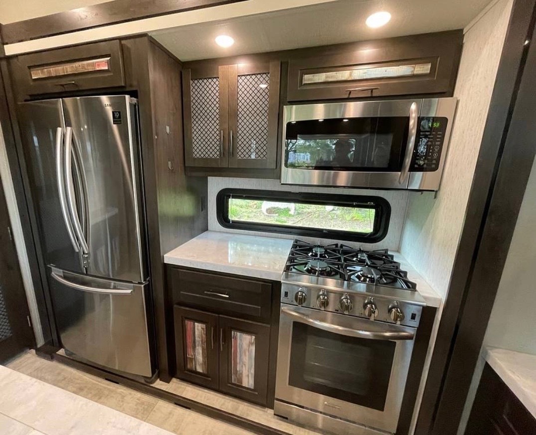 Kitchen showing residential refrigerator with freezer on bottom and full-size appliances