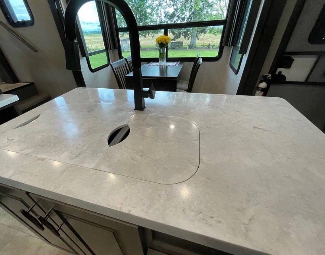 Kitchen island with built-in cutting board insert and marble countertop detail