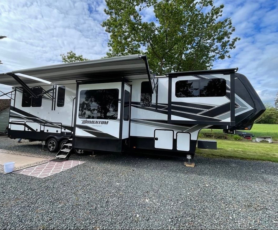 Side view of trailer fully set up with awnings and outdoor living area